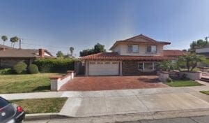 A house with red brick driveway and white garage door.