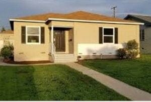 A house with grass on the front lawn